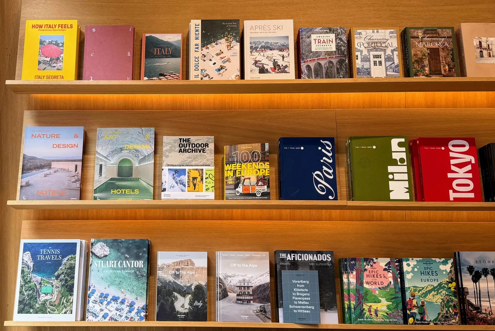 Three shelves of travel and design books and magazines, displayed face out, in a Copenhagen bookshop.
